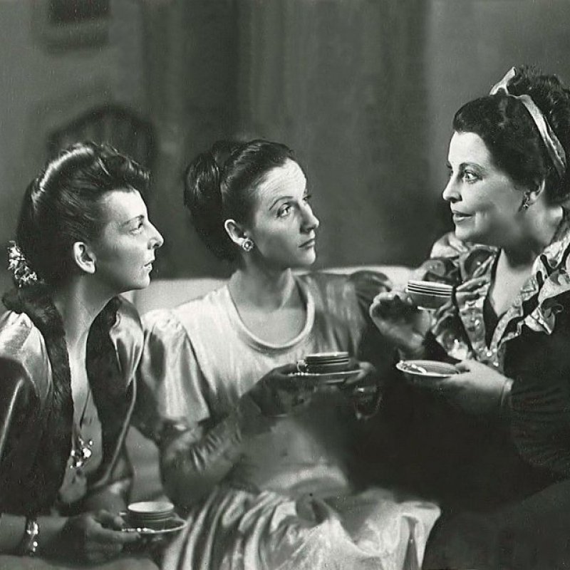 tre kvinnor dricker te i en soffa