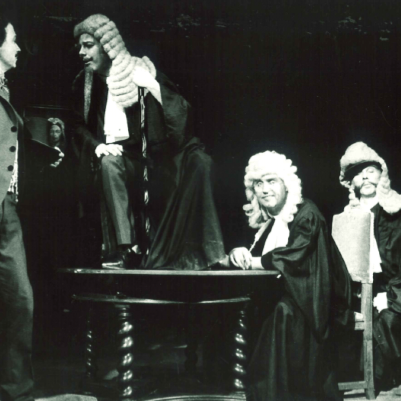 tre män i domarperuker bredvid en man i kostym