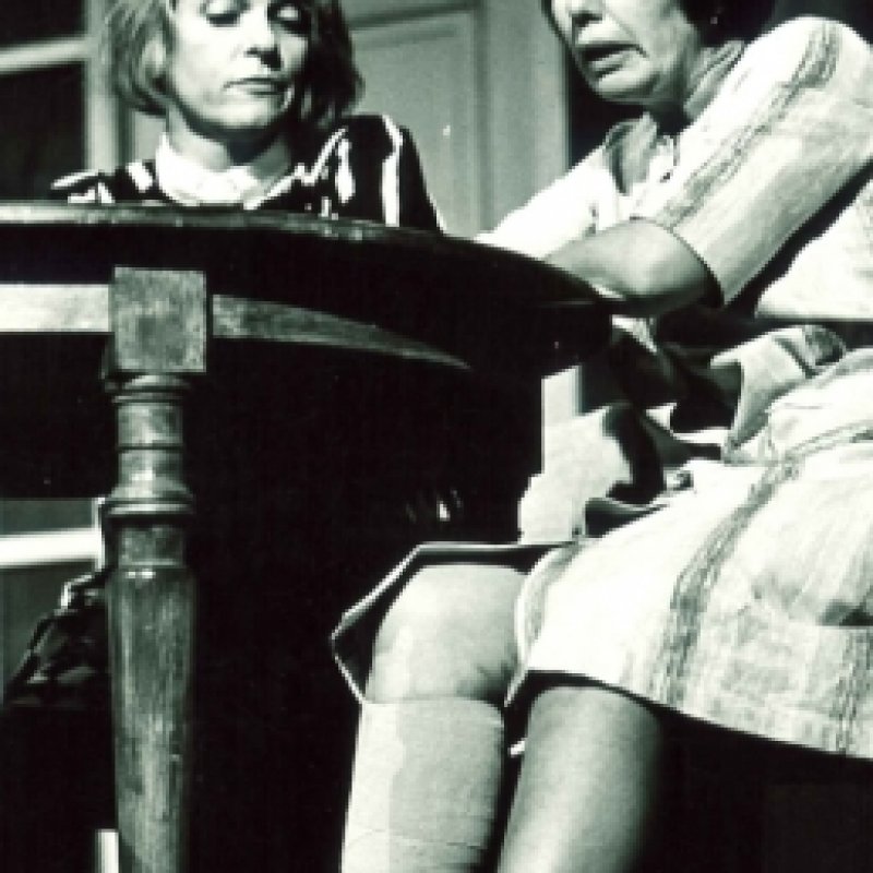 två kvinnor sitter vid bord