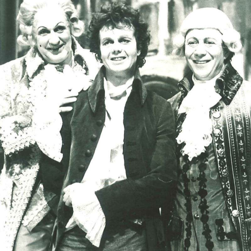 Foto av tre skådespelare i kostym