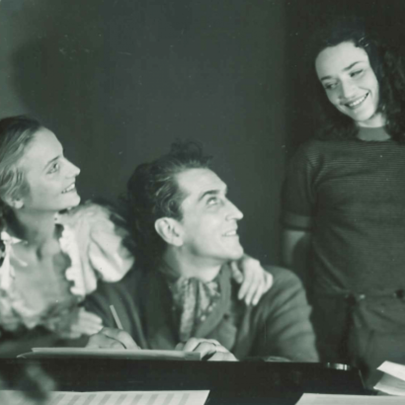 Tre leende personer vid bord