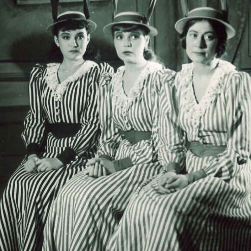 tre kvinnor i matchande kostymer