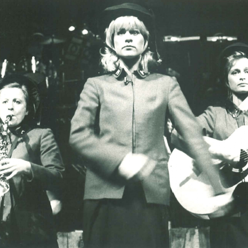 Kvinna marscherar framför musiker
