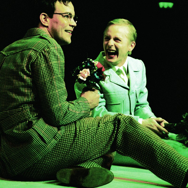 två män skrattar medan de sitter ned
