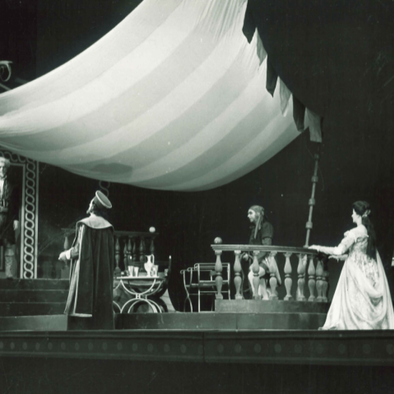 Ensemblen under ett segel på scenen