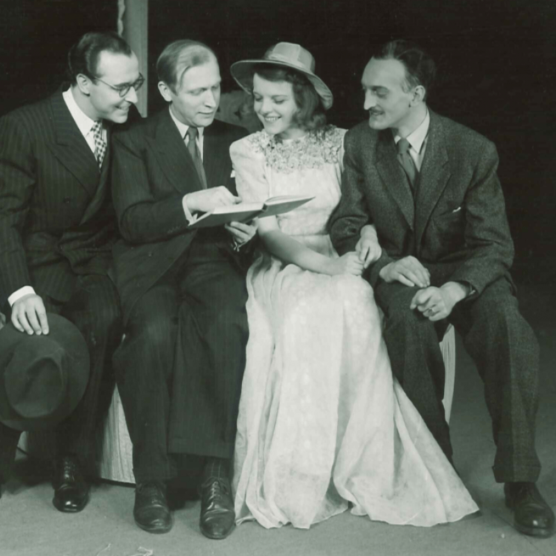 fyra personer läser på en bänk