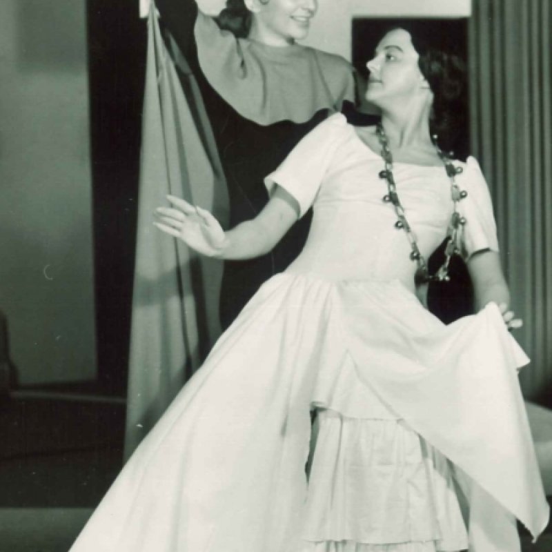 två kvinnor dansar framför kors
