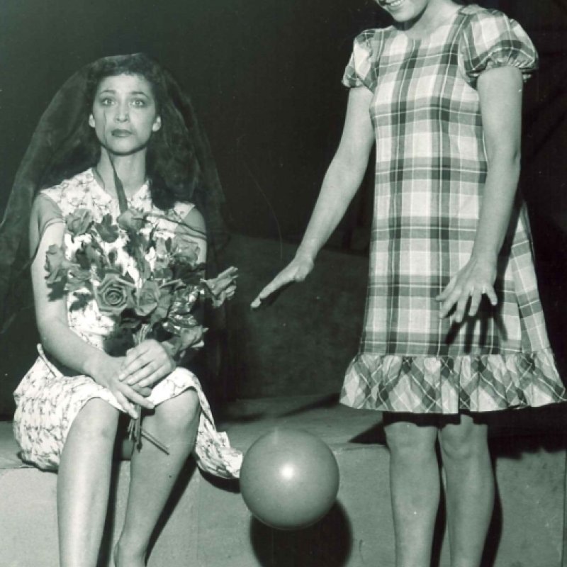 Kvinna med blommor bredvid kvinna med boll