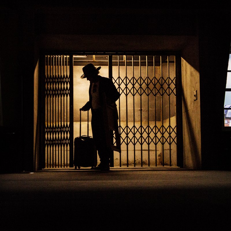 En person i siluett öppnar grindarna till den industrihiss som finns i lägenheten.