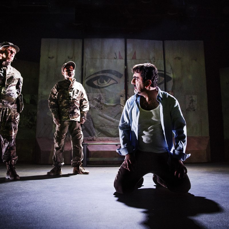 Salim sitter på knä medan två personer klädda i militära kläder står över honom.