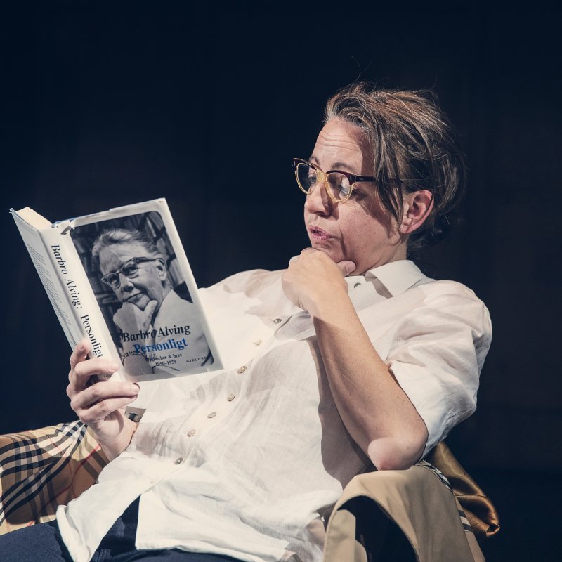 Person med glasögon som läser ur en bok