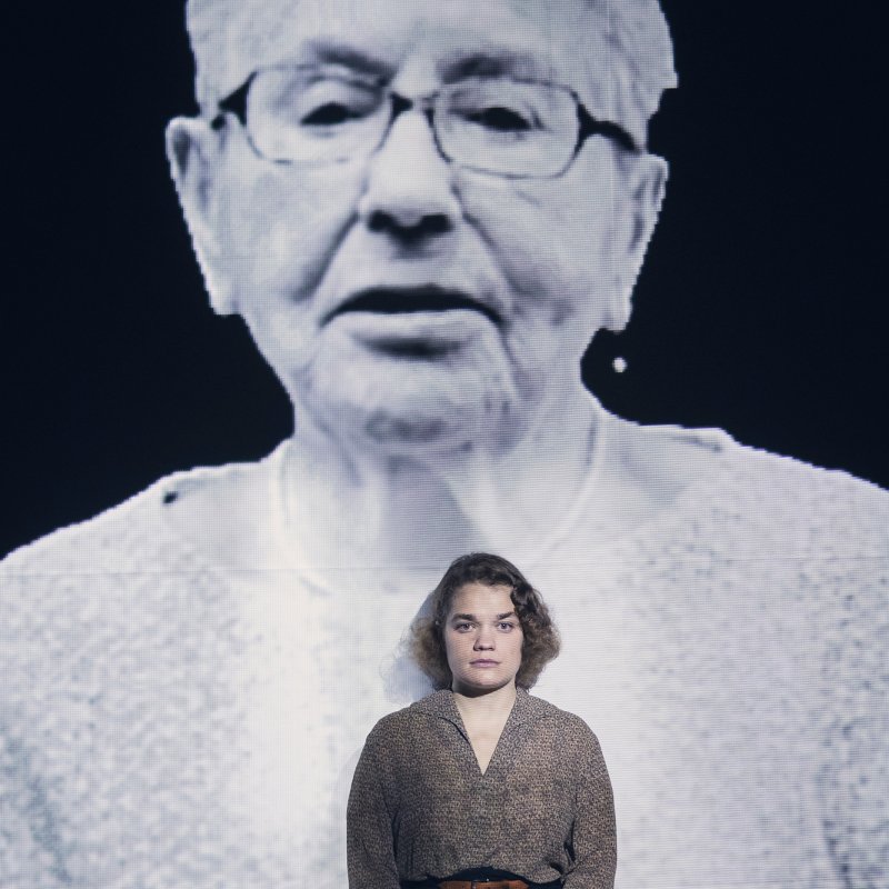 Person sitter framför ett hologram av Lea Gleitman 