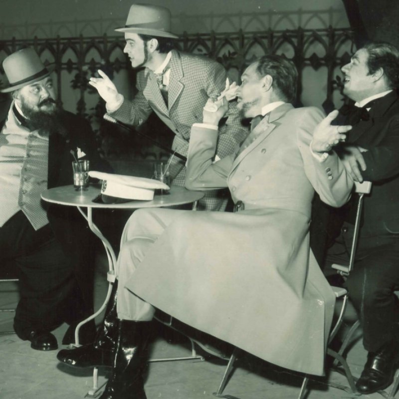 fyra män röker vid bord