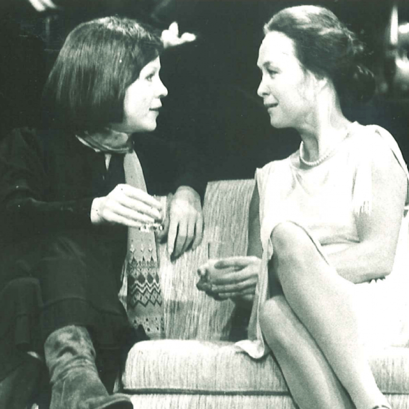 Två kvinnor pratar i en soffa
