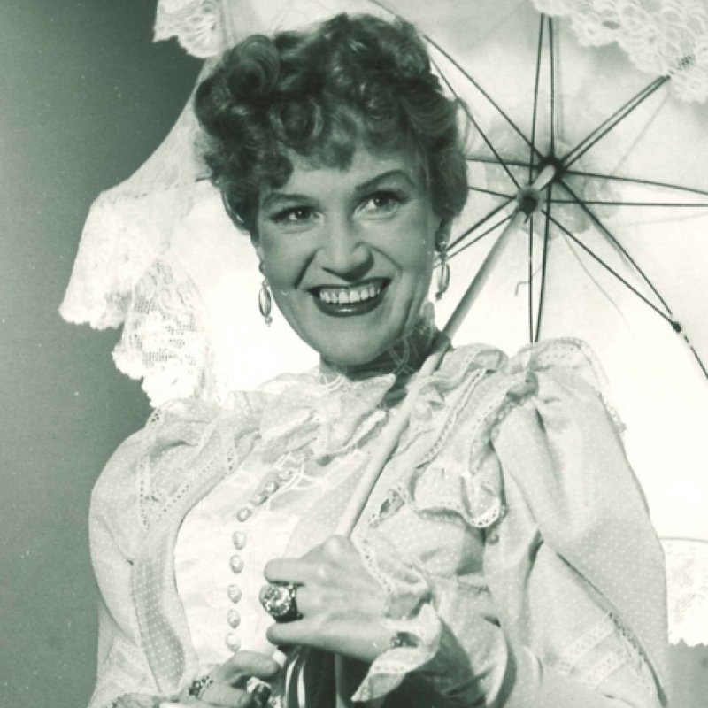 kvinna ler med paraply i handen