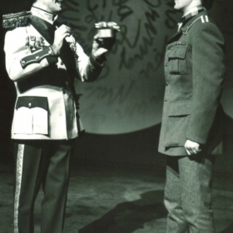 två uniformklädda män på scen