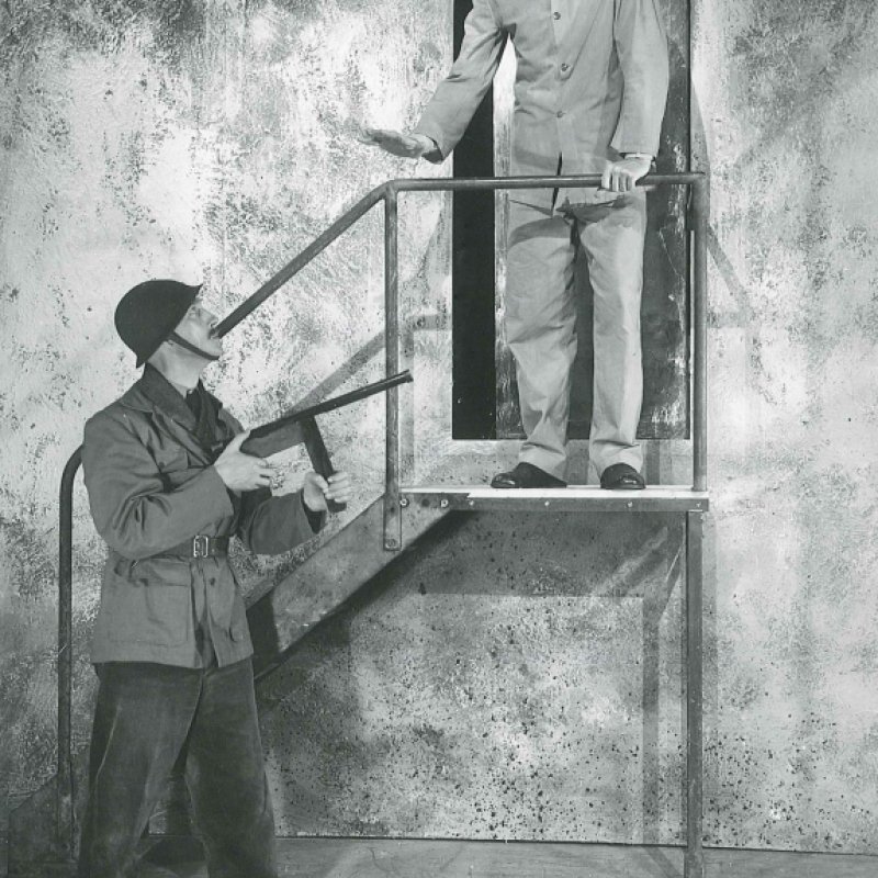 soldat riktar vapen mot man i trappa