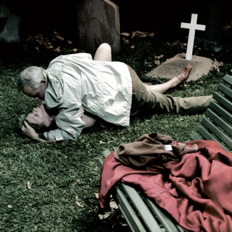 En man och en kvinna ligger på en kyrkogård
