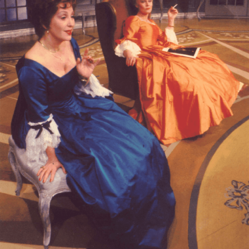 Två kvinnor i färgglada klänningar