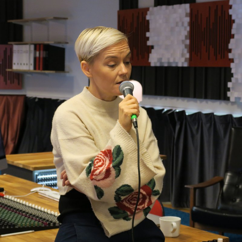 Kvinna sjunger i mikrofon.