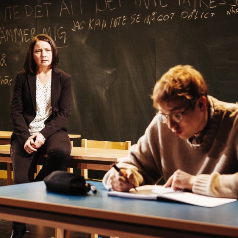 En lärare tittar på en elev i ett klassrum