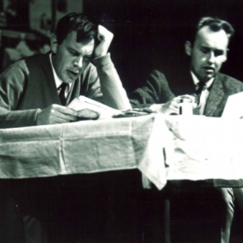 två män läser vid bord