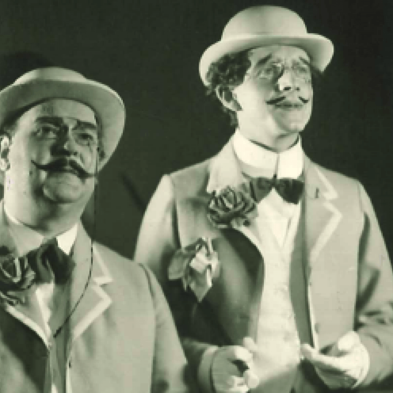 två män i hatt och mustasch