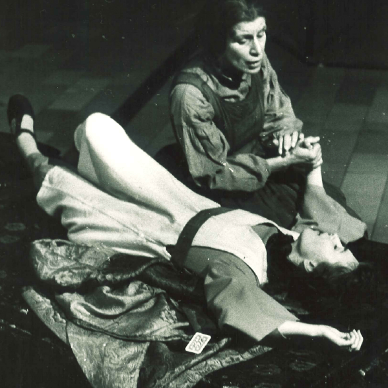Kvinna sitter bredvid liggande person