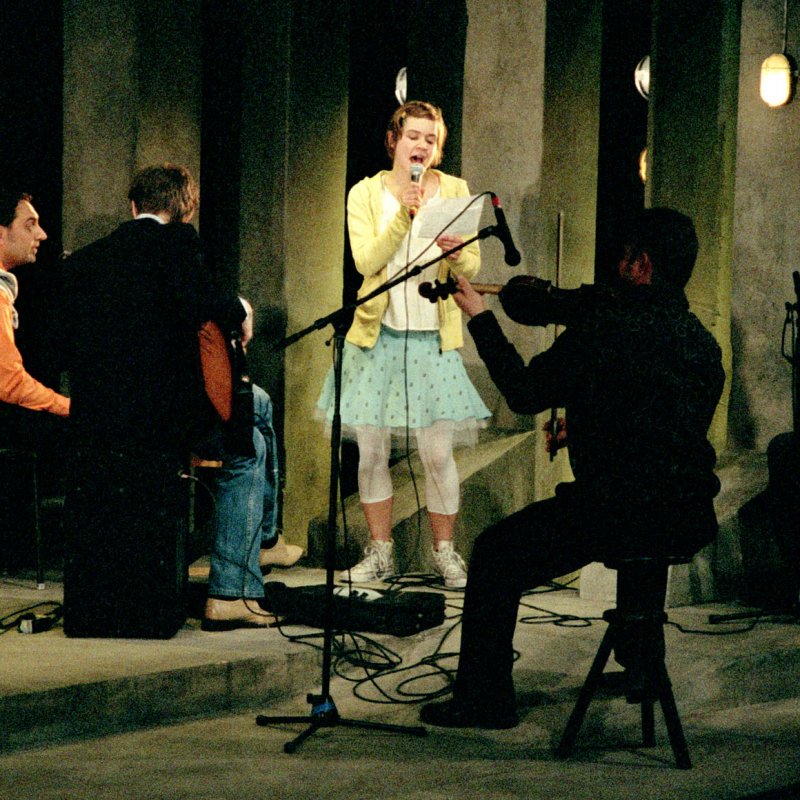 Kvinna sjunger med band
