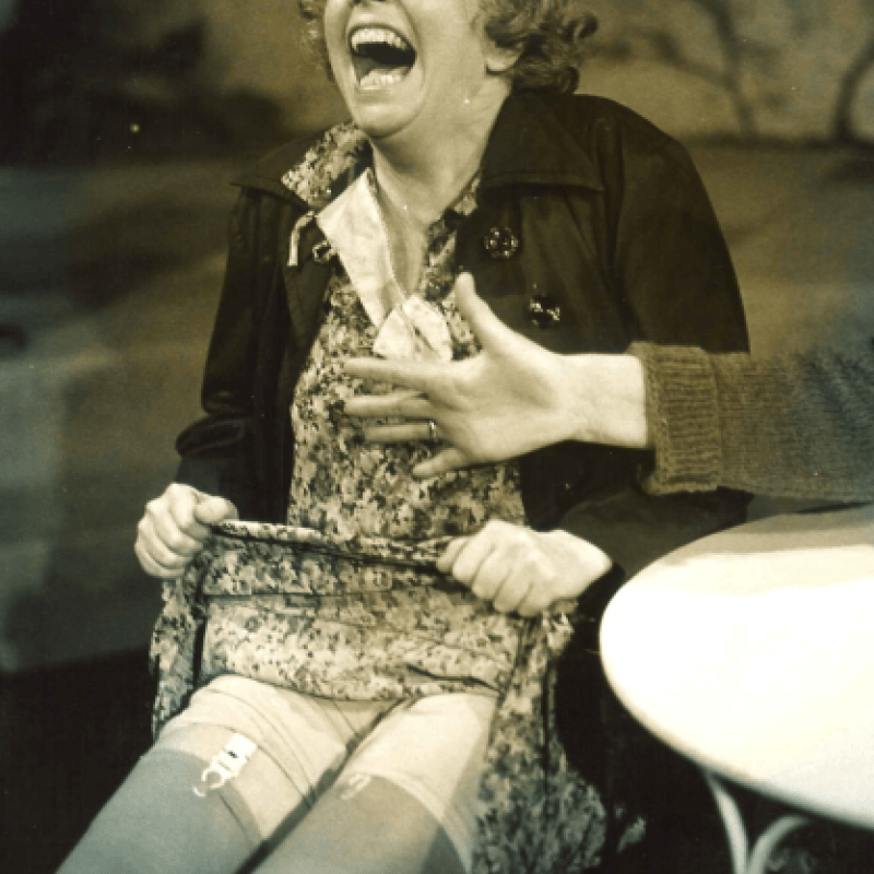 kvinna skrattar och lyfter upp sin klänning