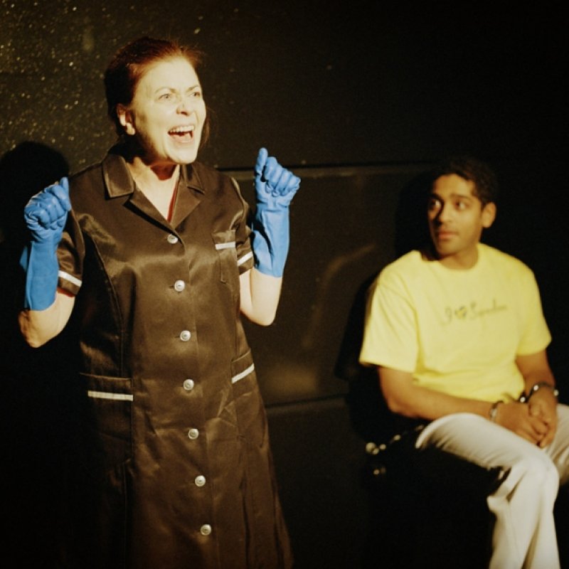 Kvinna med gummihandskar skriker bredvid en man i handfängsel