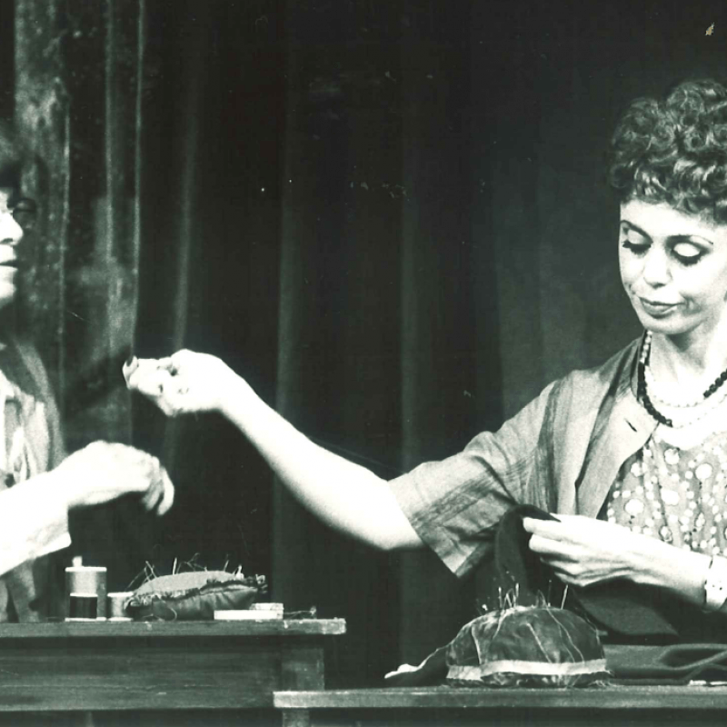 Två kvinnor syr vid bord