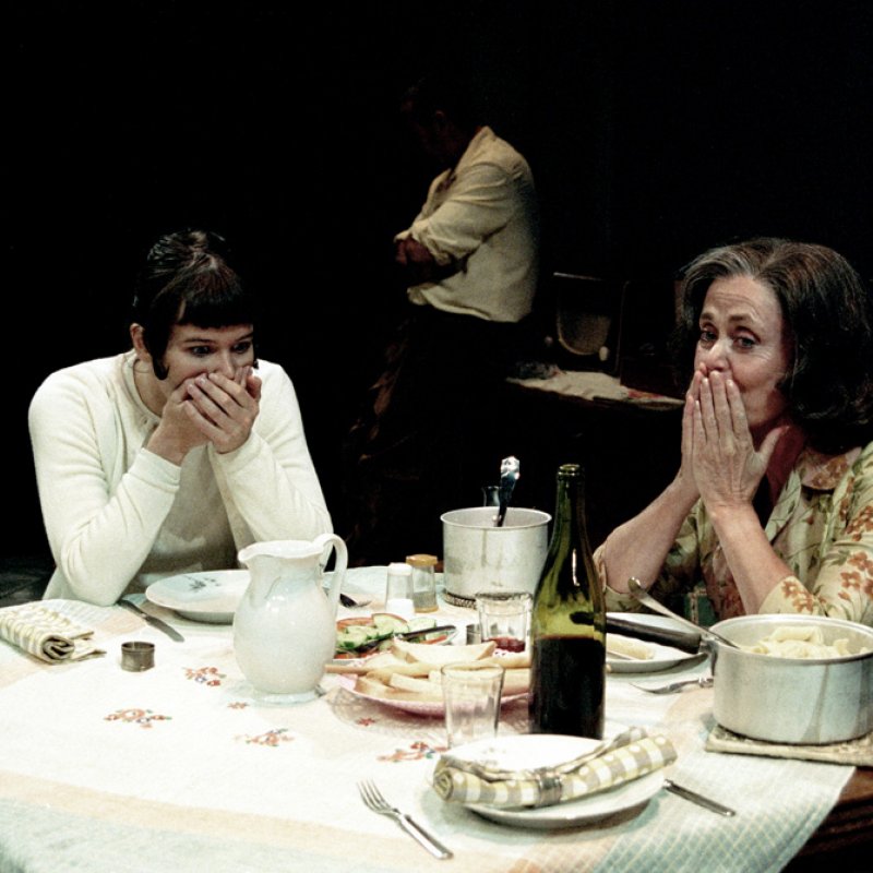 två kvinnor skrattar vid matbord