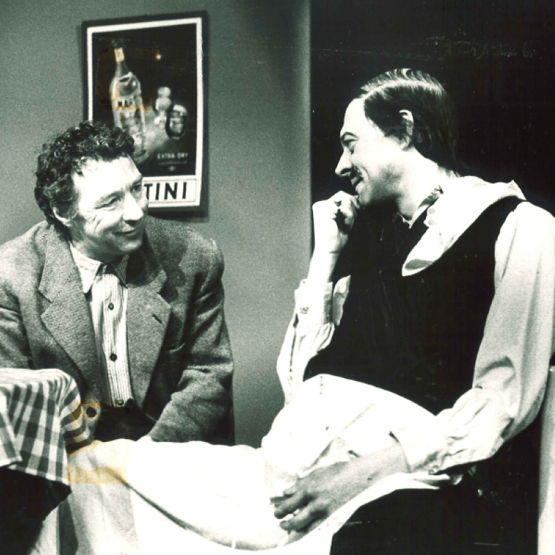 Två män talar vid bord