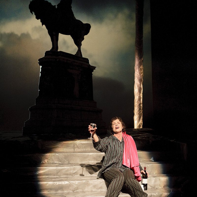 Kvinna sitter på en trappa med vin i handen