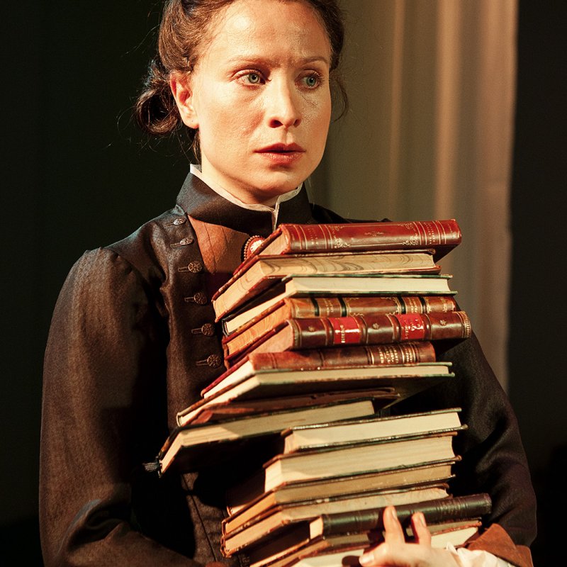 Kvinna bär en stapel med böcker