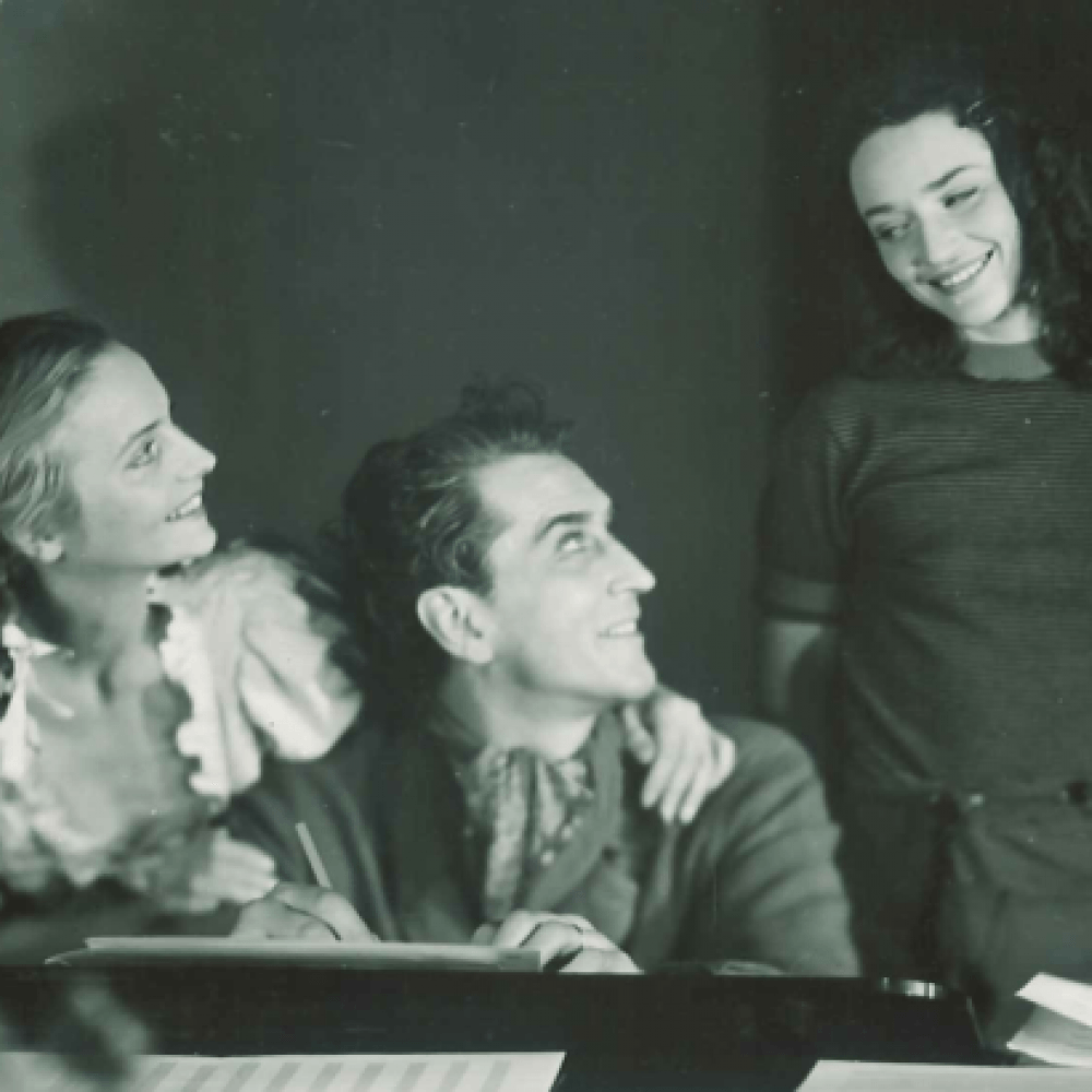 Tre leende personer vid bord