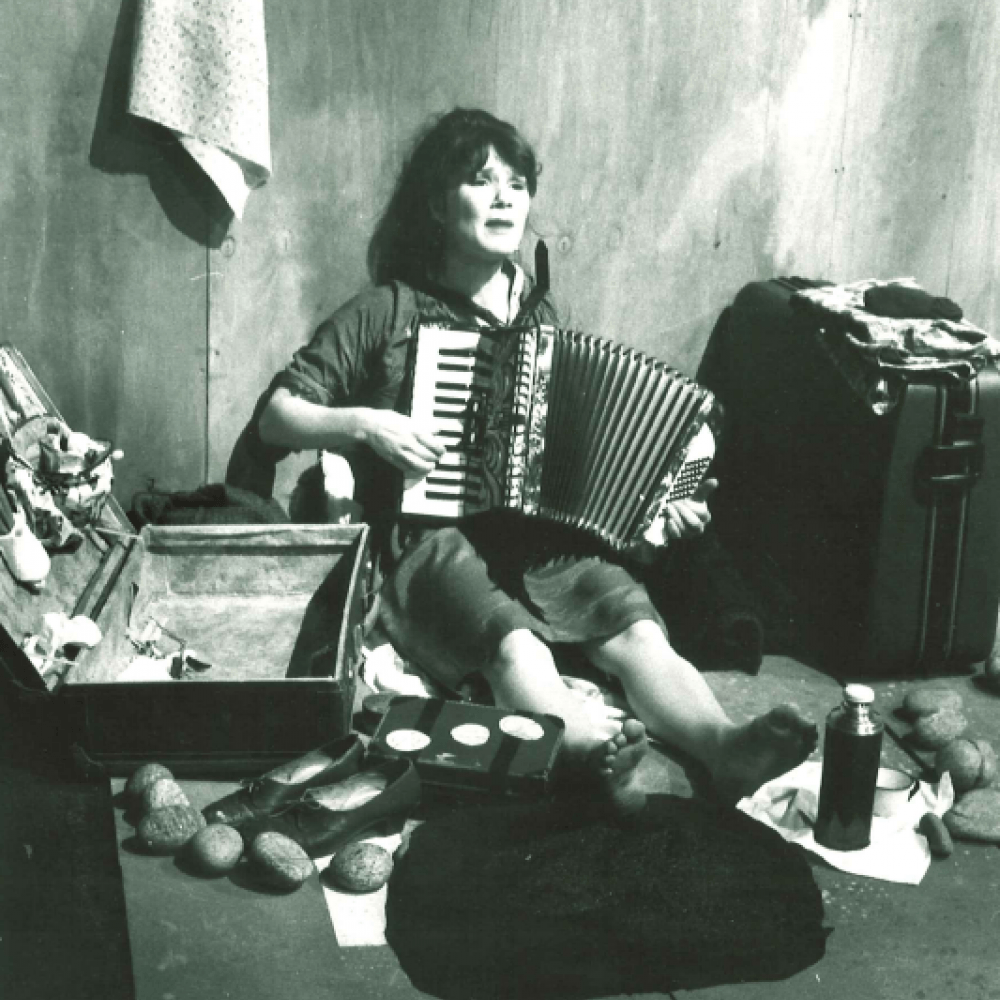 Kvinna sitter på golvet och spelar dragspel