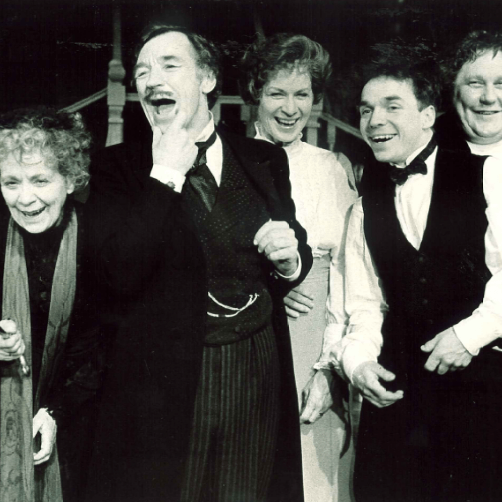 Fem personer skrattar på scen