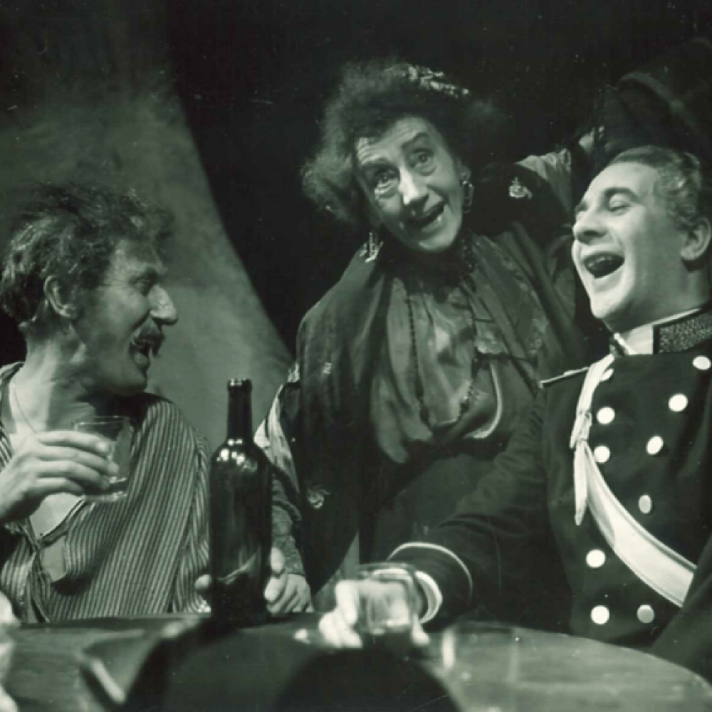 kvinna och två män skrattar och dricker