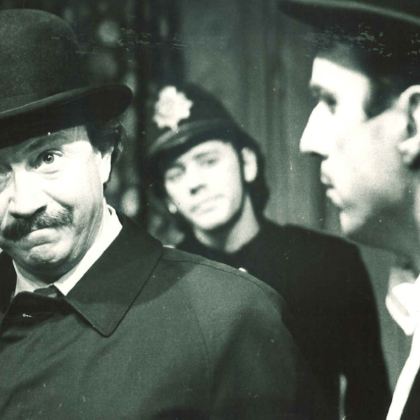 man med hatt framför poliskonstapel