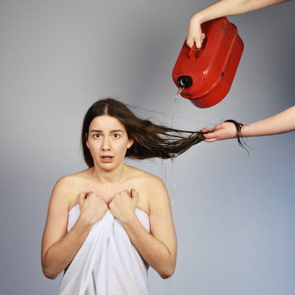 Kvinna får håret tvättat med bensin
