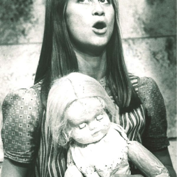 Kvinna med docka i famnen