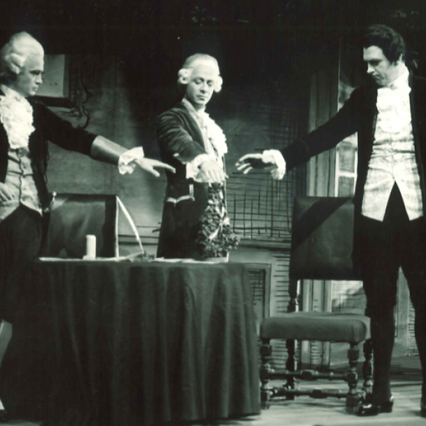 Tre män sträcker händerna mot varandra