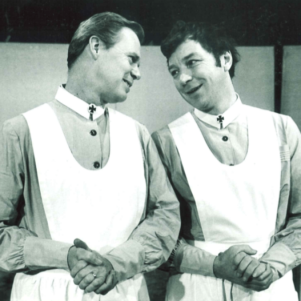Två sjuksköterskor ler mot varandra