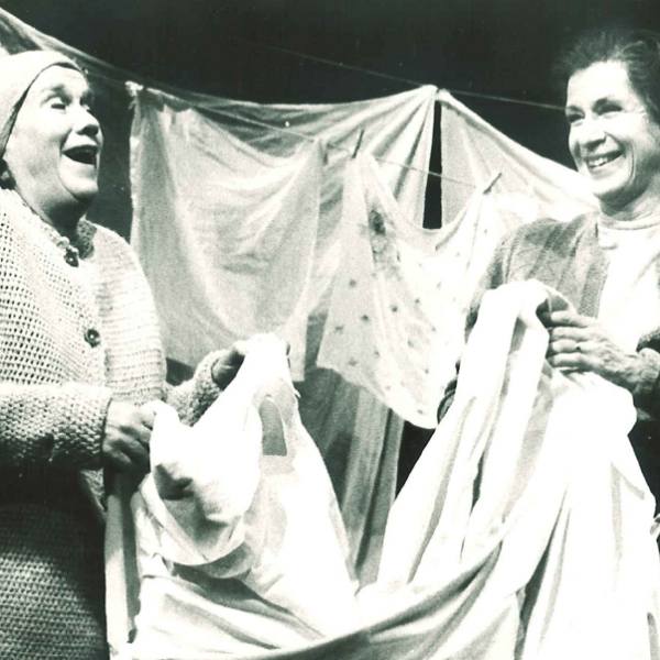 Två kvinnor skrattar medan de hänger tvätt