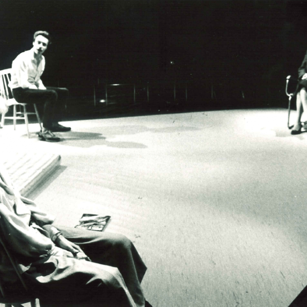 Tre personer sitter långt ifrån varandra på scenen